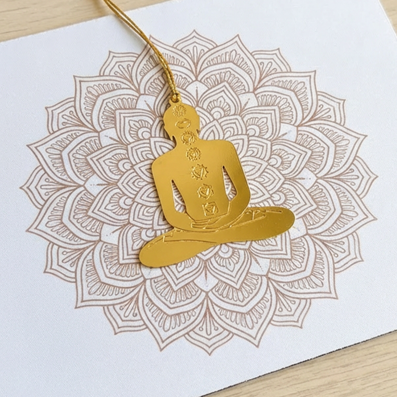 Gold Yogi figure on a white card with a mandala design